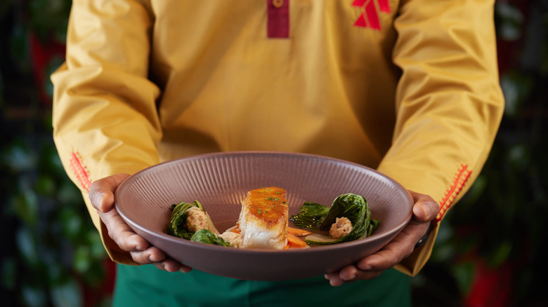 server holding plate with food